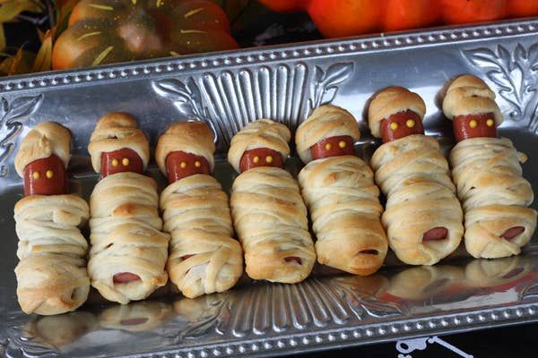 Hot dogs wrapped in golden crescent dough with candy eyes and a crispy texture.