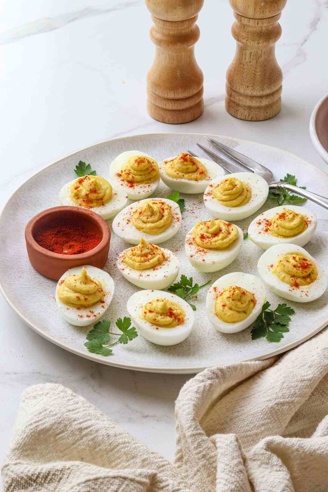 Creamy yolk filling with paprika, chives, and bacon bits on hard-boiled eggs
