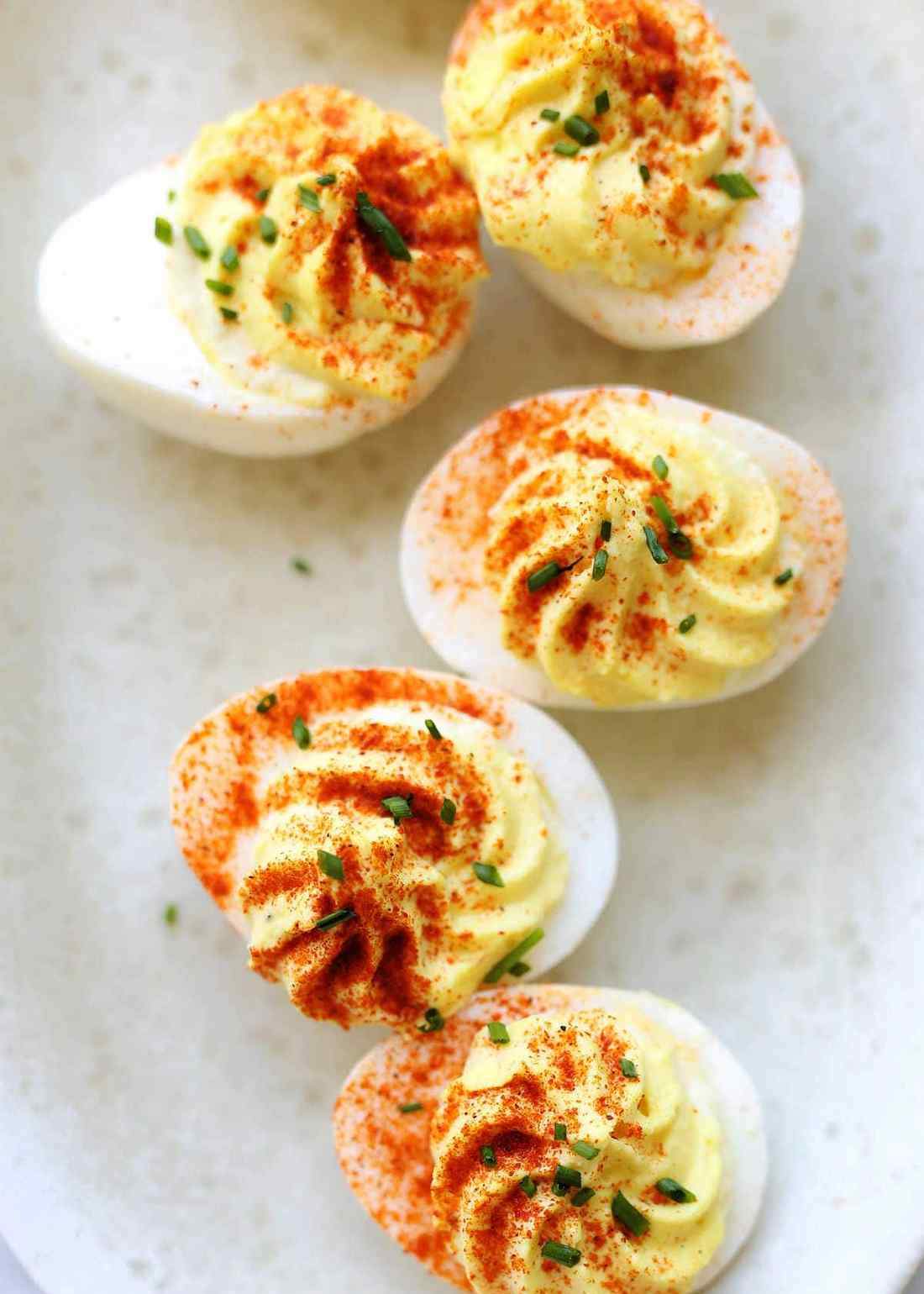 Creamy yolk filling with paprika, chives, and bacon bits on hard-boiled eggs