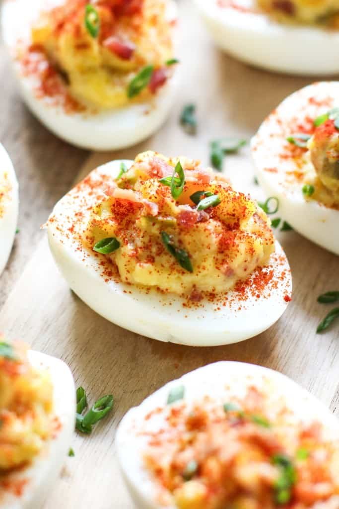 Bacon deviled eggs with creamy yolk filling, smoky bacon, paprika, and fresh chives