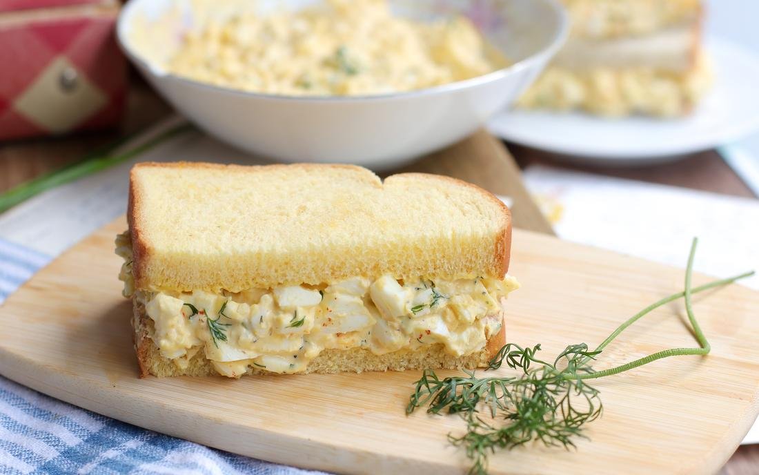 Smoky chipotle egg salad sandwich with roasted peppers, creamy mayo, and crunchy lettuce in a toasted ciabatta roll