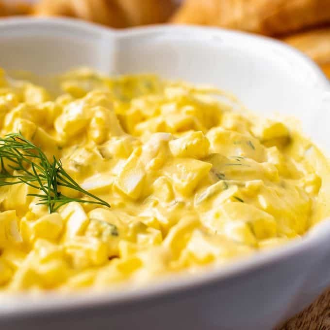 Classic creamy egg salad with chopped hard‑boiled eggs, silky mayo, fresh chives, on a rustic sandwich