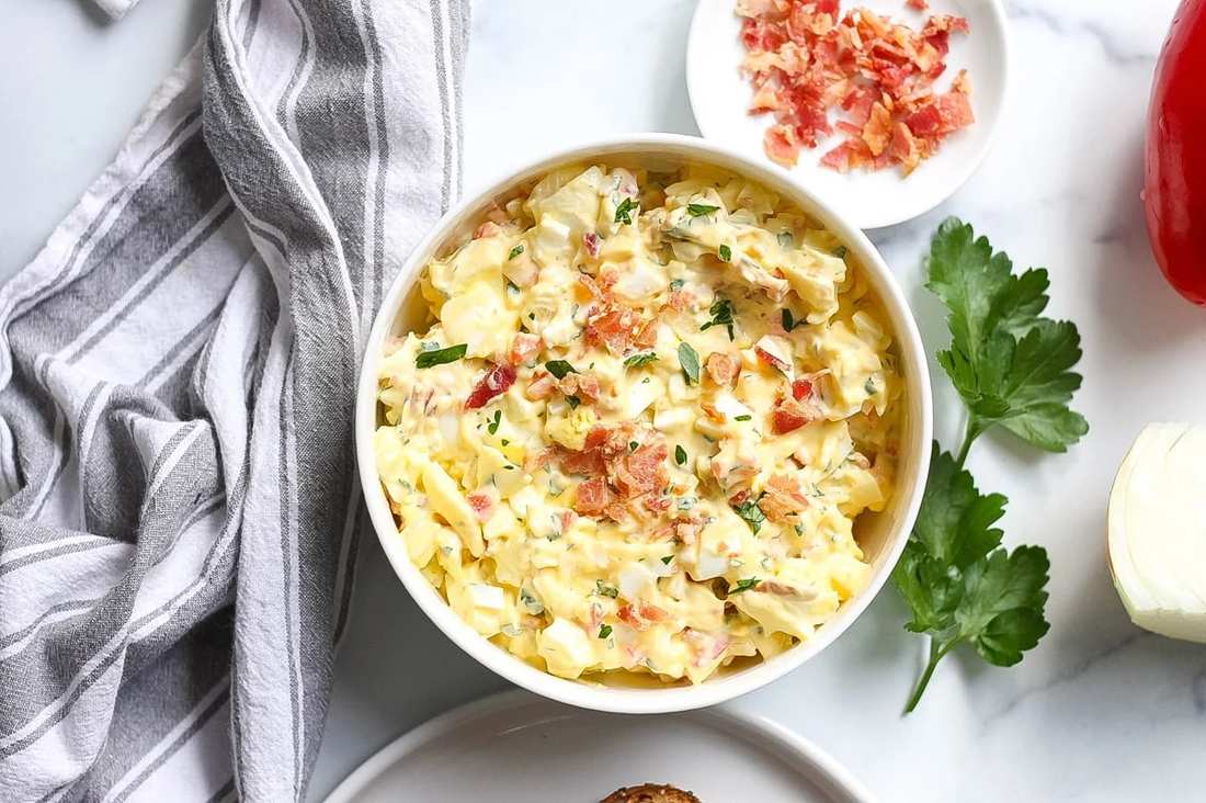 Classic creamy egg salad with chopped hard-boiled eggs, mayo, fresh dill, served on sandwich