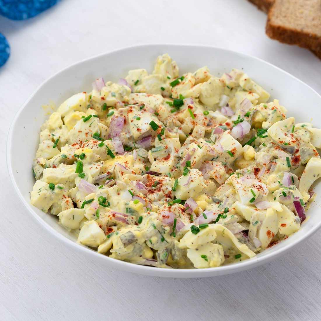 Classic creamy egg salad with chopped hard-boiled eggs, smooth mayo, dill, and a sprinkle of paprika, served in a rustic bowl.