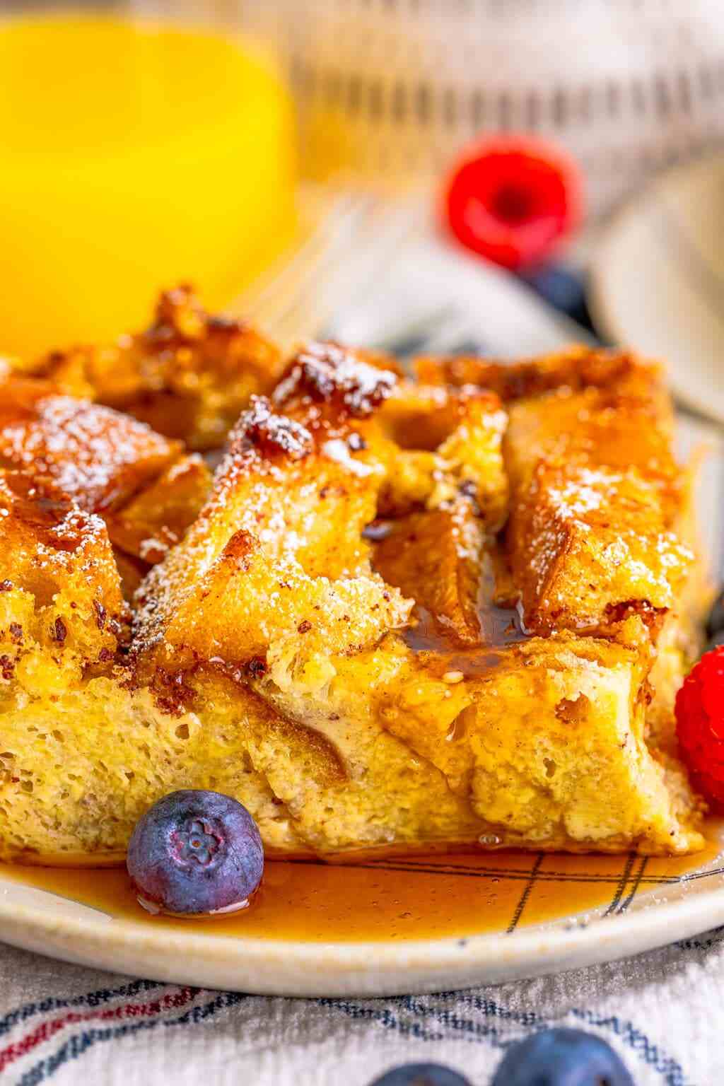 Rustic french toast casserole with caramelized bread cubes, fresh fruit, and maple syrup drizzle