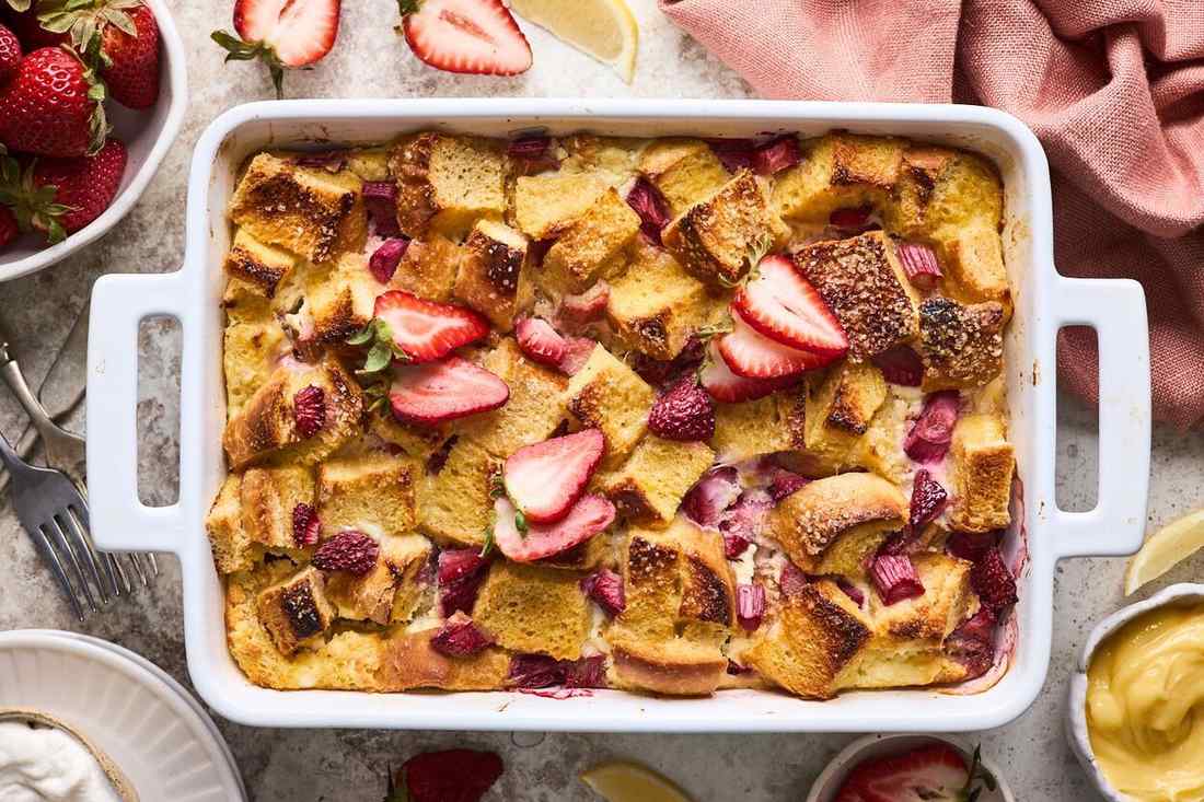 Golden custardy bread cubes studded with fresh strawberries, topped with a sweet glaze and fresh berries