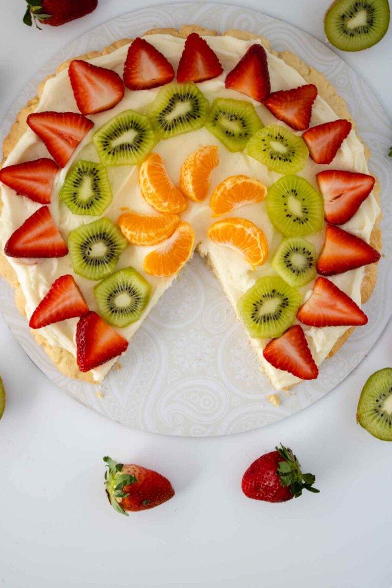 Sugar cookie fruit pizza with cream cheese frosting, fresh figs, honey drizzle, and blueberries