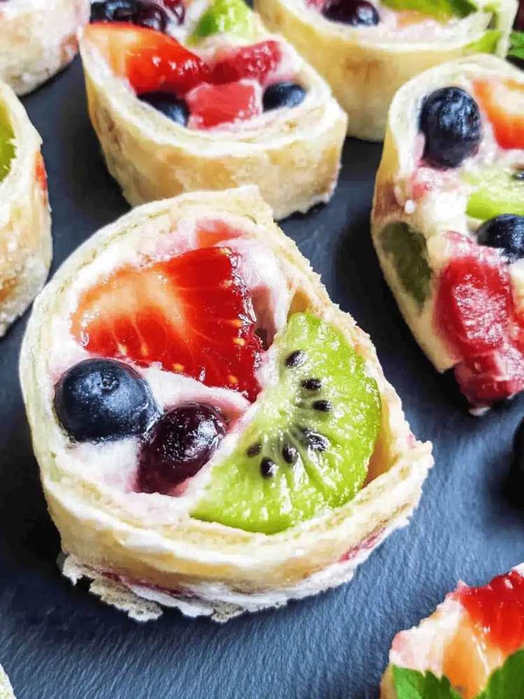 Sugar cookie base with orange‑zest cream cheese frosting, sliced oranges, blood oranges, and pomegranate seeds, vibrant citrus fruit pizza