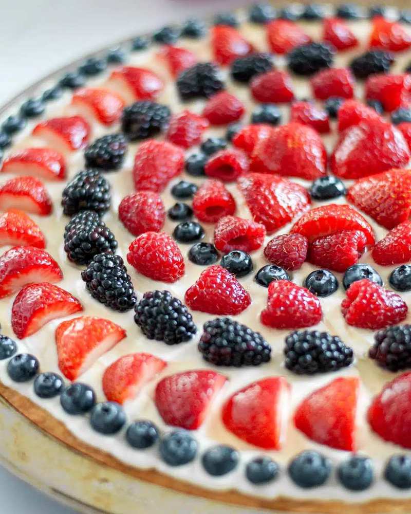 buttery shortbread crust topped with vanilla cream cheese frosting and mixed berries, elegant fruit pizza tart