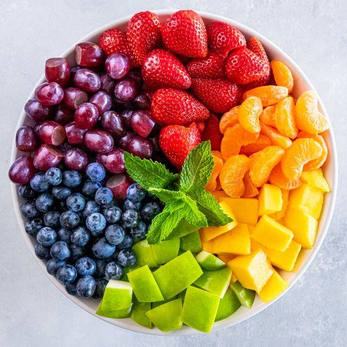 Tropical rainbow fruit salad with mango, papaya, berries, and a coconut‑lime drizzle