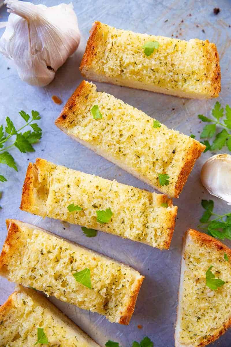 Baguette boats drenched in garlic butter, golden crust, and fresh herbs