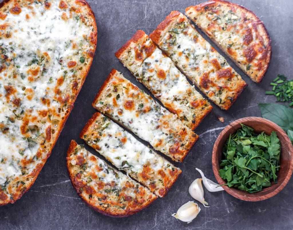 Classic garlic bread with golden crust, buttery garlic, melted mozzarella, and parsley