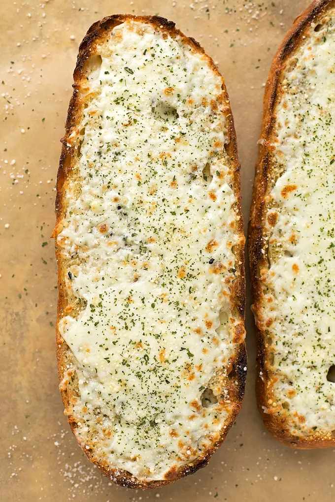 Cheesy garlic bread with golden crust, melted mozzarella, garlic butter, and parsley garnish
