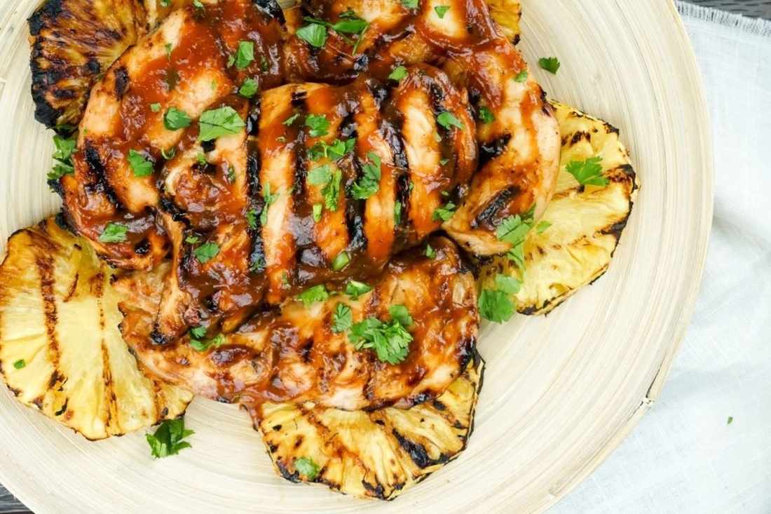 Grilled pineapple chicken with crisp broccoli, tangy dressing, toasted nuts, dried fruit, and cheese.
