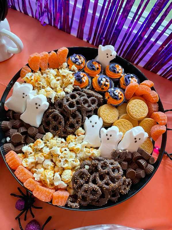 A tray of sweet treats with ghost-shaped marshmallow peeps and candy.