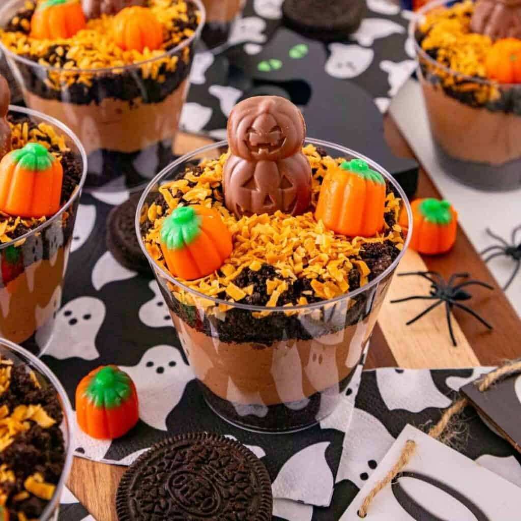 Chocolate pudding topped with crushed Oreo “dirt,” gummy worms, and a tombstone chocolate wafer.
