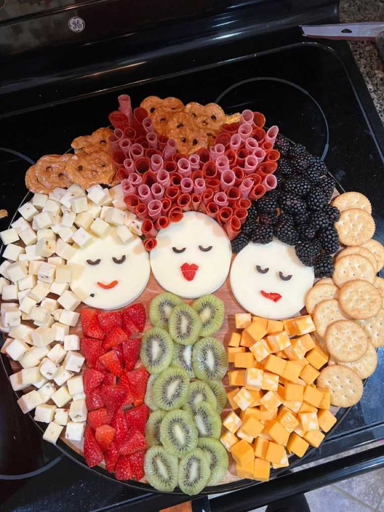 A charcuterie board with three sections representing the Sanderson Sisters.