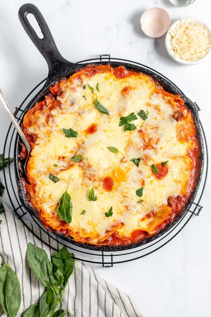 Skillet lasagna layers pasta, sauce, and cheese, bubbling golden atop a stovetop.