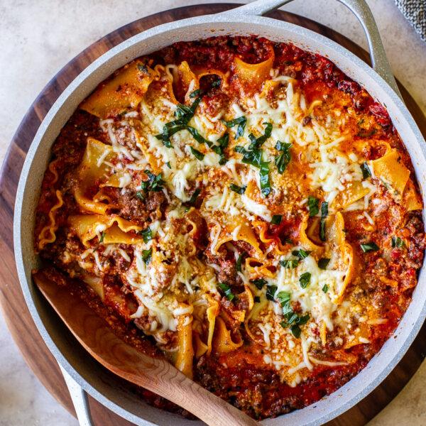 Layered skillet lasagna with roasted red peppers, bubbling cheese, and fragrant herbs.