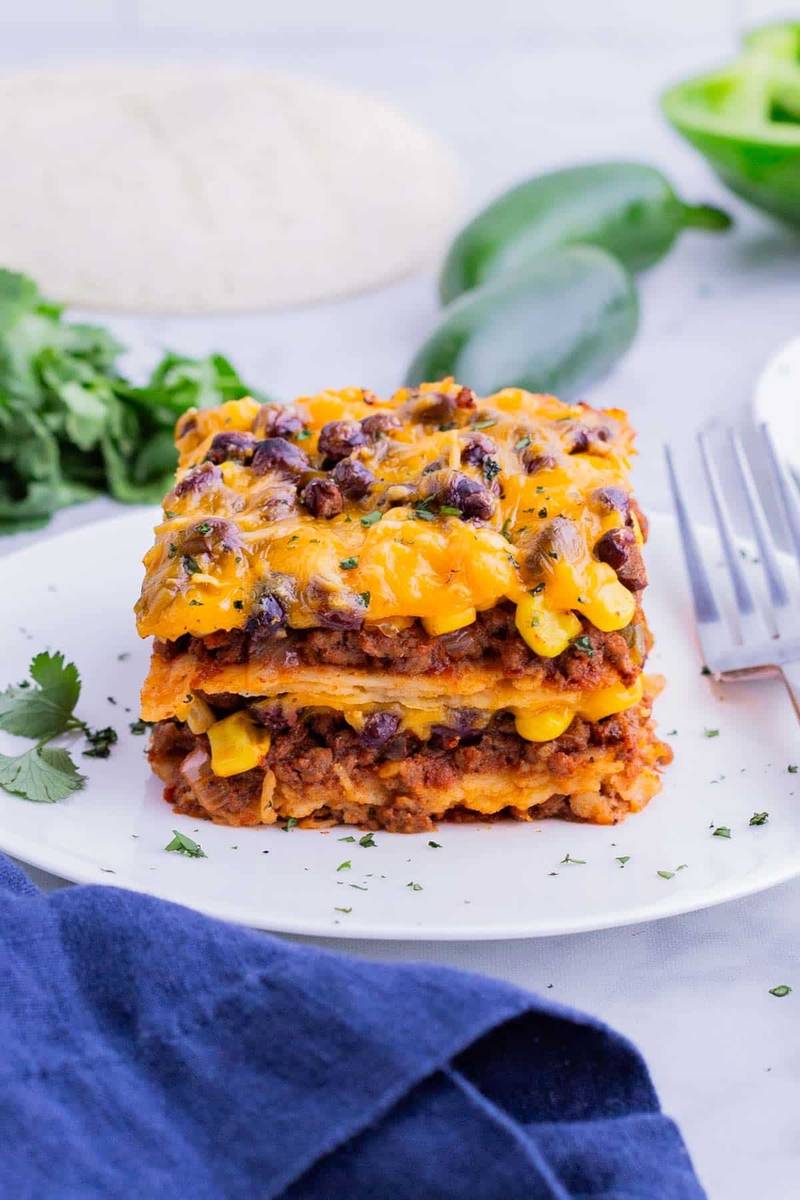 Layers of black beans, chipotle sauce, and melty cheese create a spicy Mexican taco lasagna.