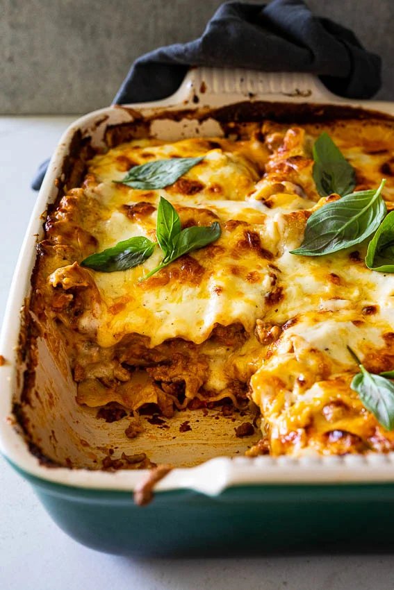 Golden four‑cheese lasagna layers of pasta, bubbling mozzarella, ricotta, parmesan, and gorgonzola