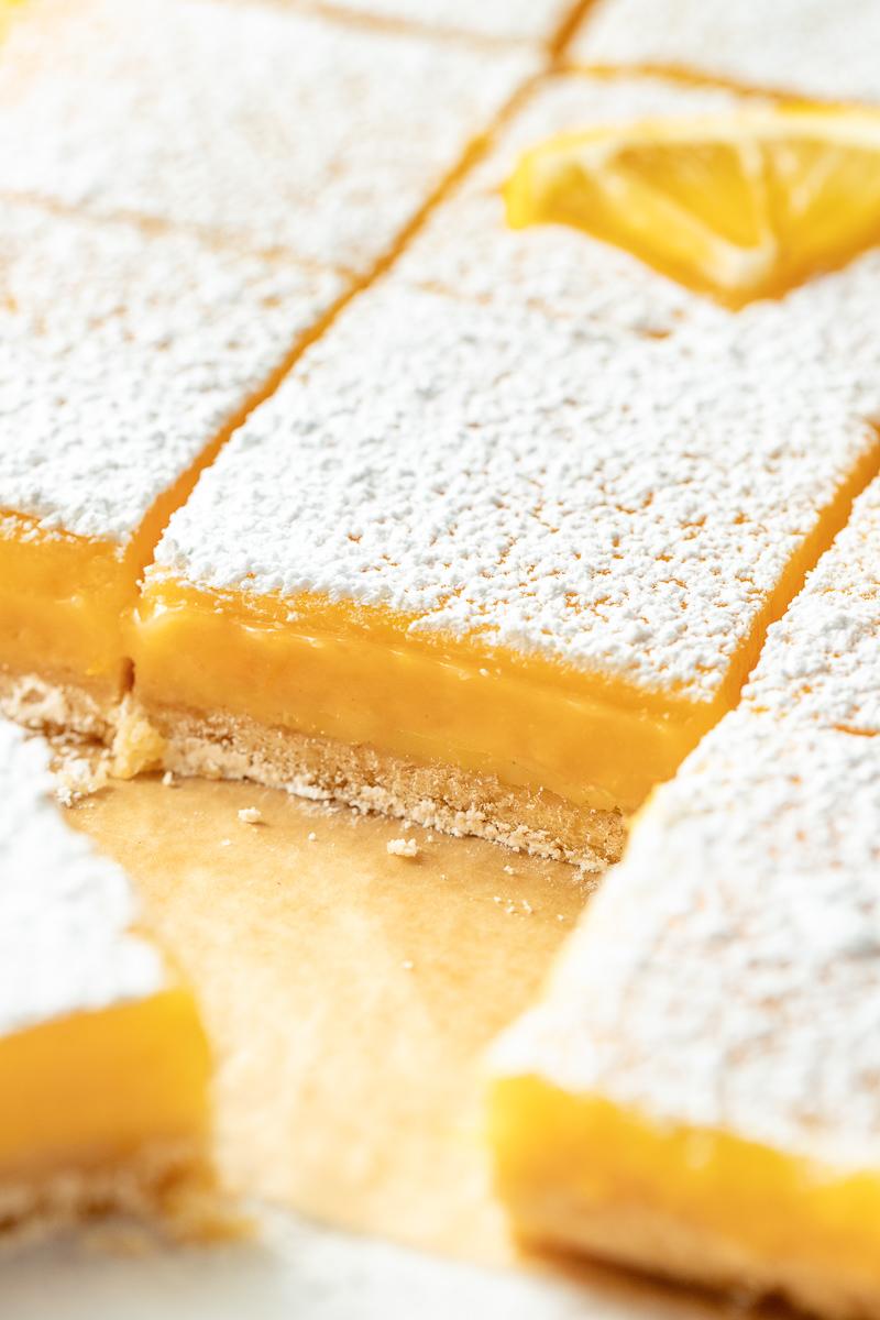 Meyer lemon bars with buttery crust, velvety curd, lightly dusted powdered sugar, fragrant citrus aroma