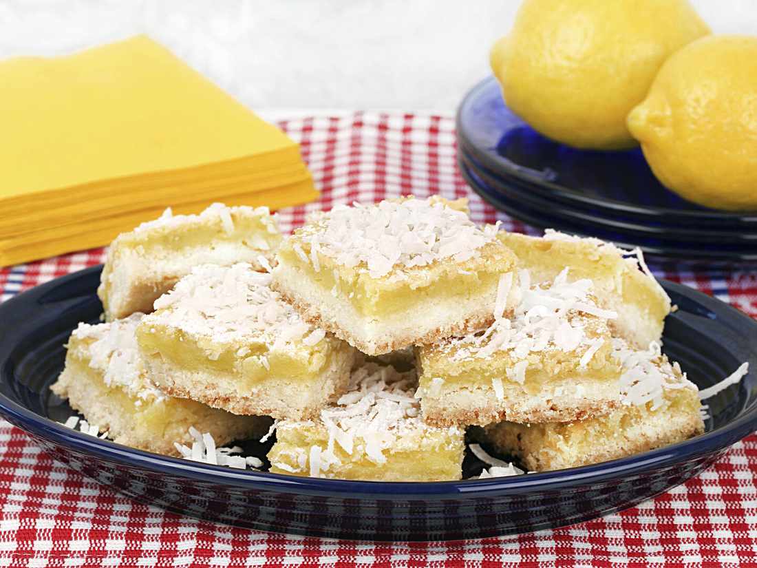 Vegan lemon bars with golden shortbread crust, bright lemon curd, dusted with powdered sugar