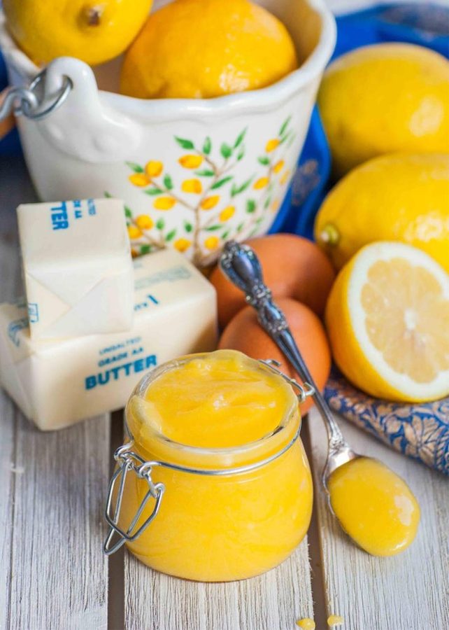 Easy lemon curd in a small saucepan, bright yellow, smooth, with a lemon wedge garnish