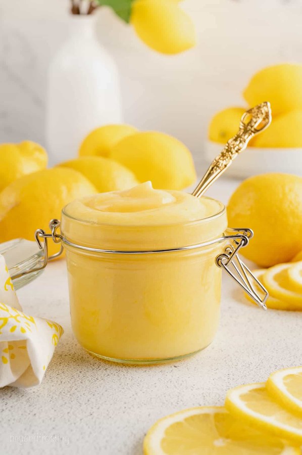 Lemon curd piped into a layered cake, bright citrus, smooth, with fresh berries on top