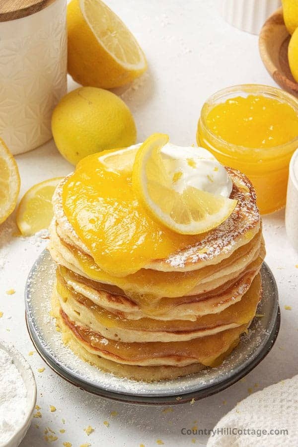 Stacked lemon pancakes smothered in lemon curd and a drizzle of honey