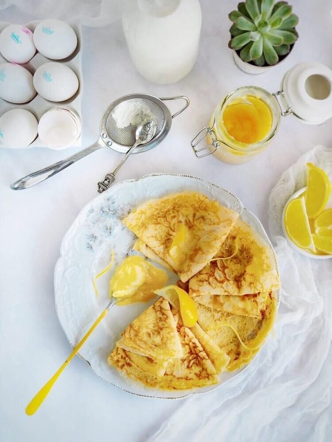 Thin lemon‑scented crepes rolled around silky lemon curd and powdered sugar