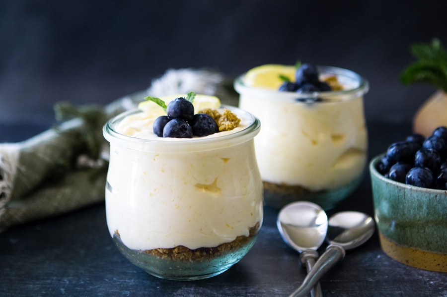 Light lemon mousse with a glossy swirl of lemon curd and powdered sugar