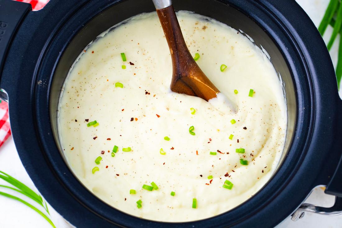 Cheesy slow cooker mashed potatoes loaded with sharp cheddar, melted butter, and fresh garden herbs