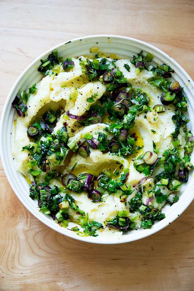 Creamy buttery herb mashed potatoes with roasted garlic, melted cheese, and fresh chives in warm bowl