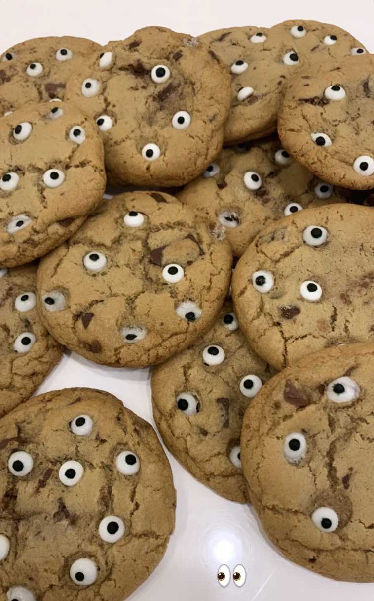 Soft chocolate chip cookies topped with pink frosting “eyeballs” made from candy and sprinkles.