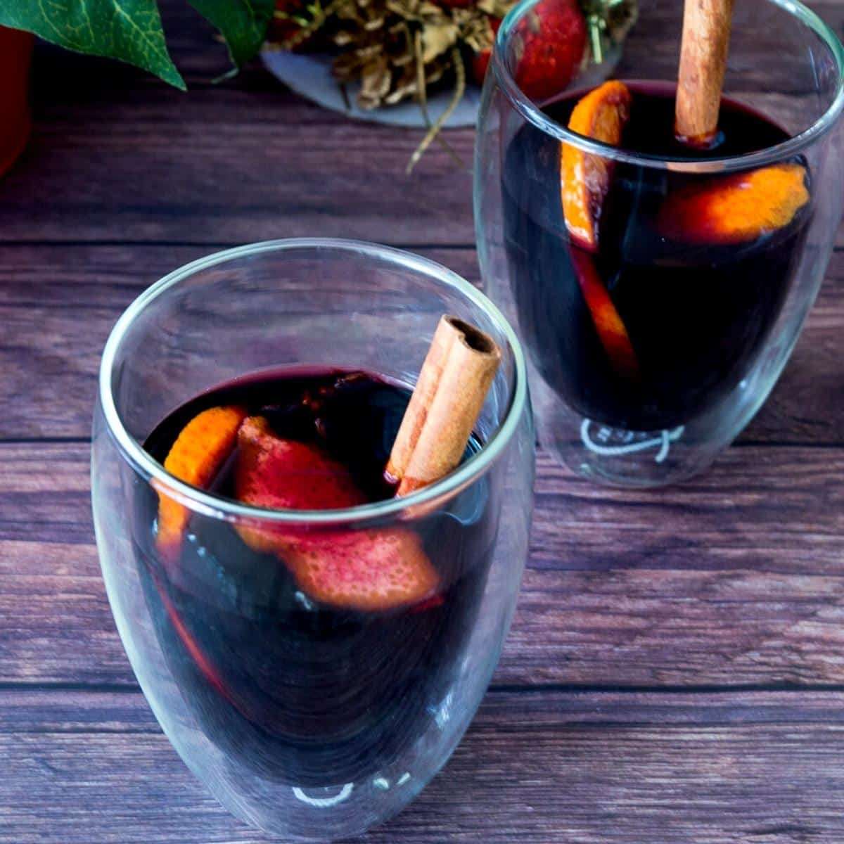 Vanilla bean spiced mulled wine in a glass mug with floating star anise and sliced oranges