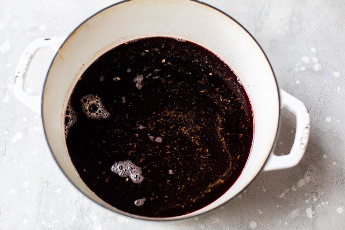 Slow cooker spiced red wine spiked with Kentucky bourbon, orange slices, and star anise