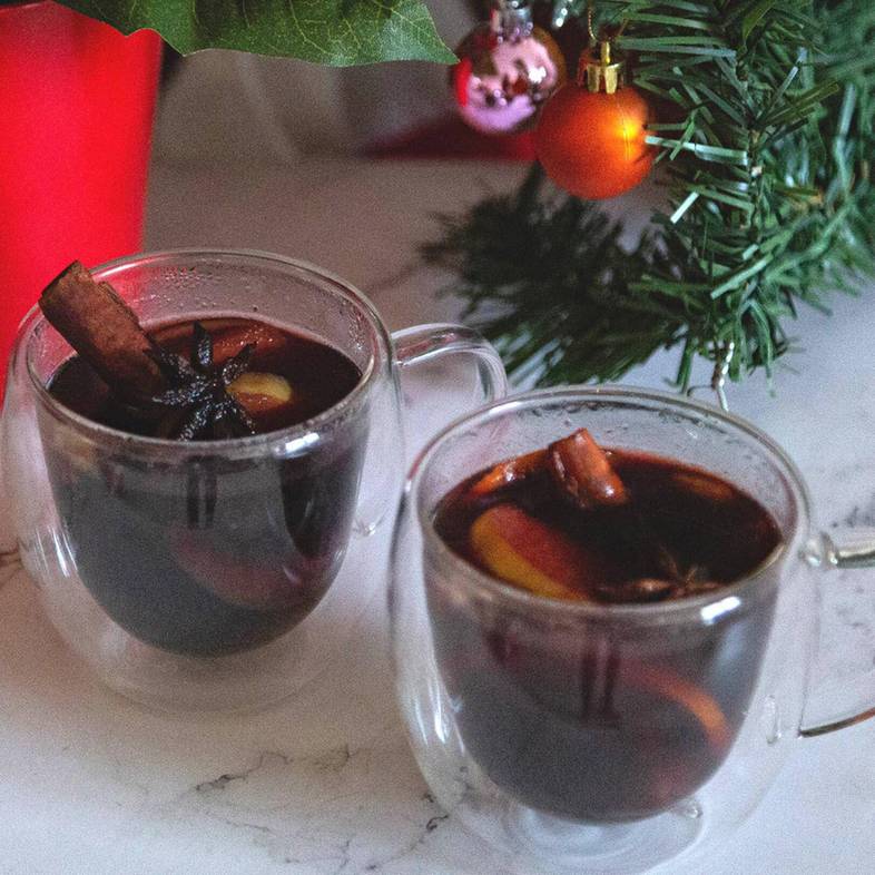 Chai spiced homemade mulled wine with cinnamon, cardamom, clove, and orange peel in glass mug