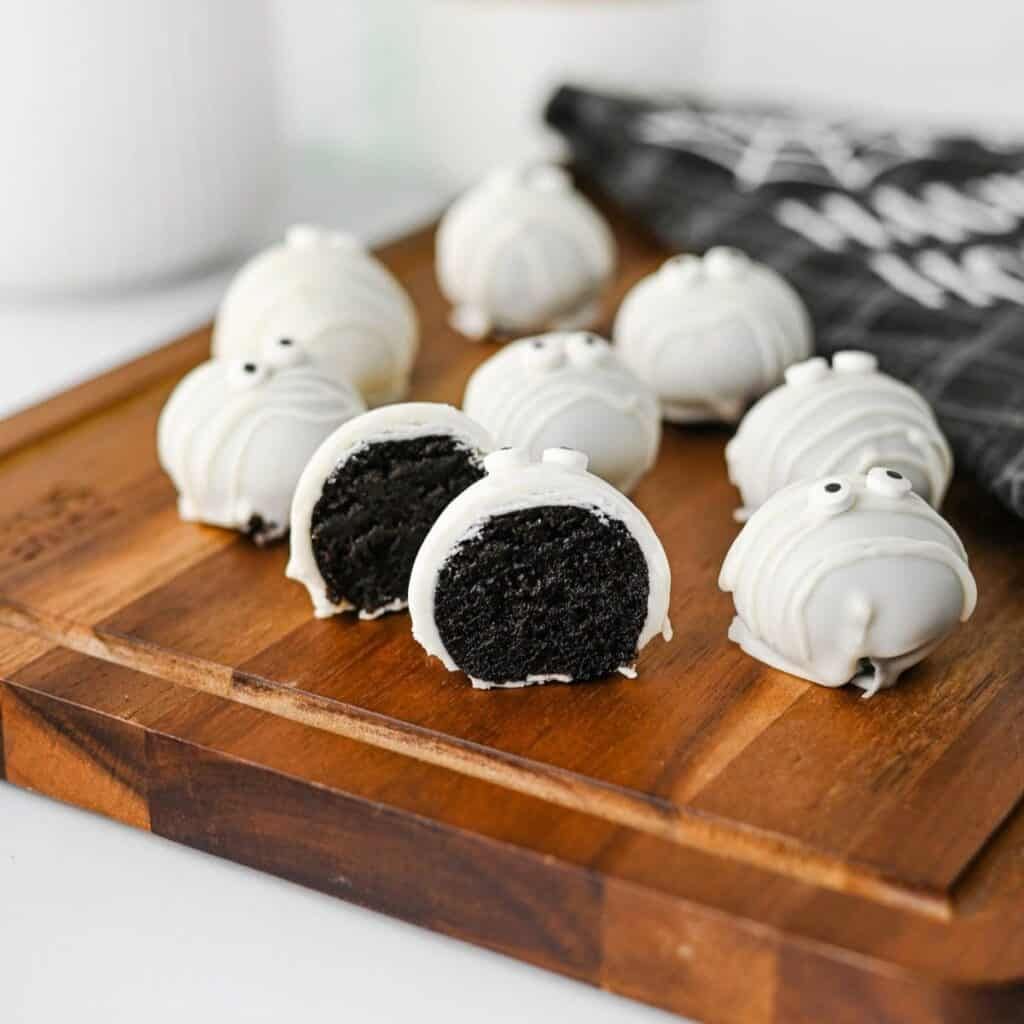 White chocolate‑coated Oreo truffles wrapped in shredded coconut “bandages,” with two dark chocolate eyes.