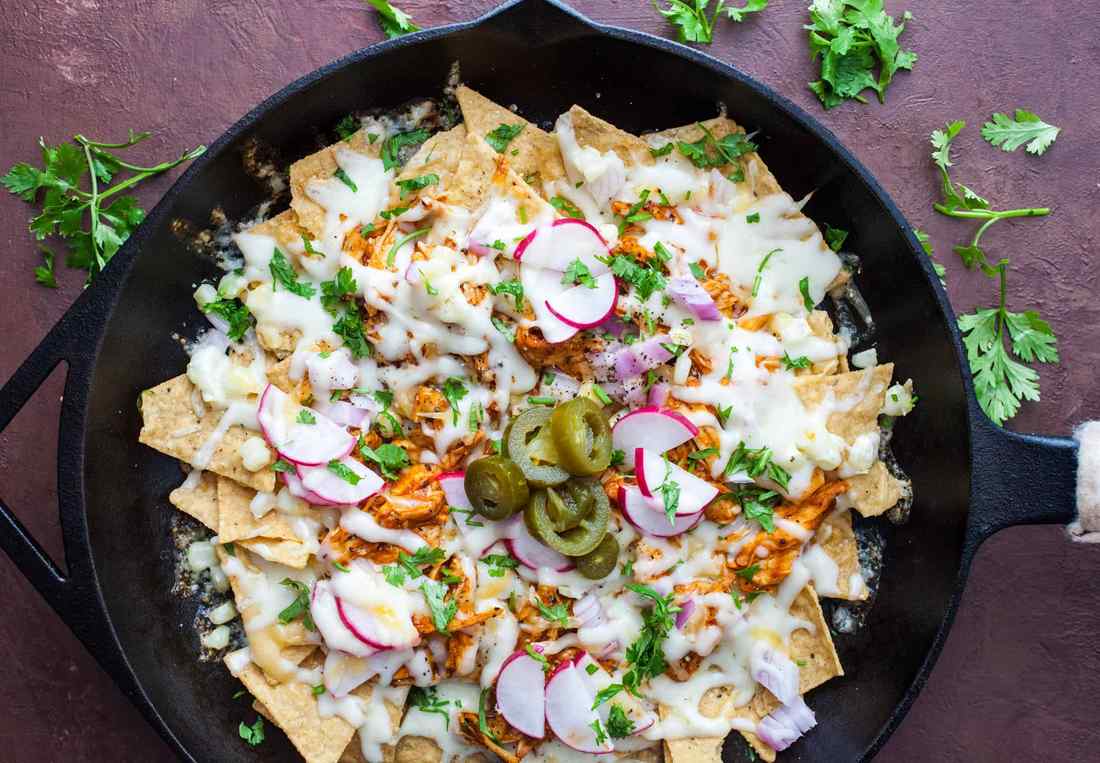 Loaded BBQ chicken nachos with roasted sweet corn, melted monterey jack cheese, jalapeños, and loaded tortilla chips