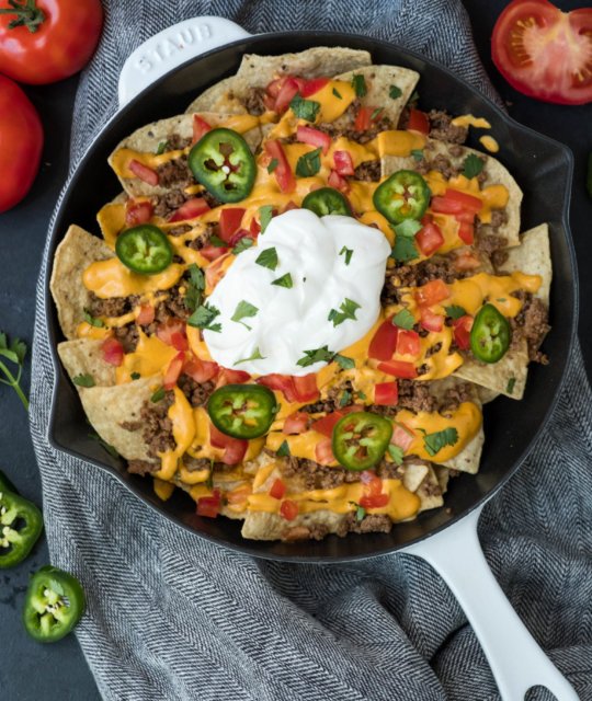 Classic loaded nachos layered with gooey melted cheese, sliced jalapeños, guacamole, sour cream, and crispy tortilla chips.