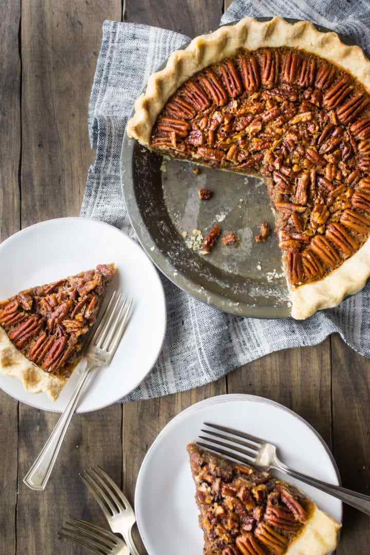 Classic southern pecan pie slice with bourbon caramel filling on rustic plate