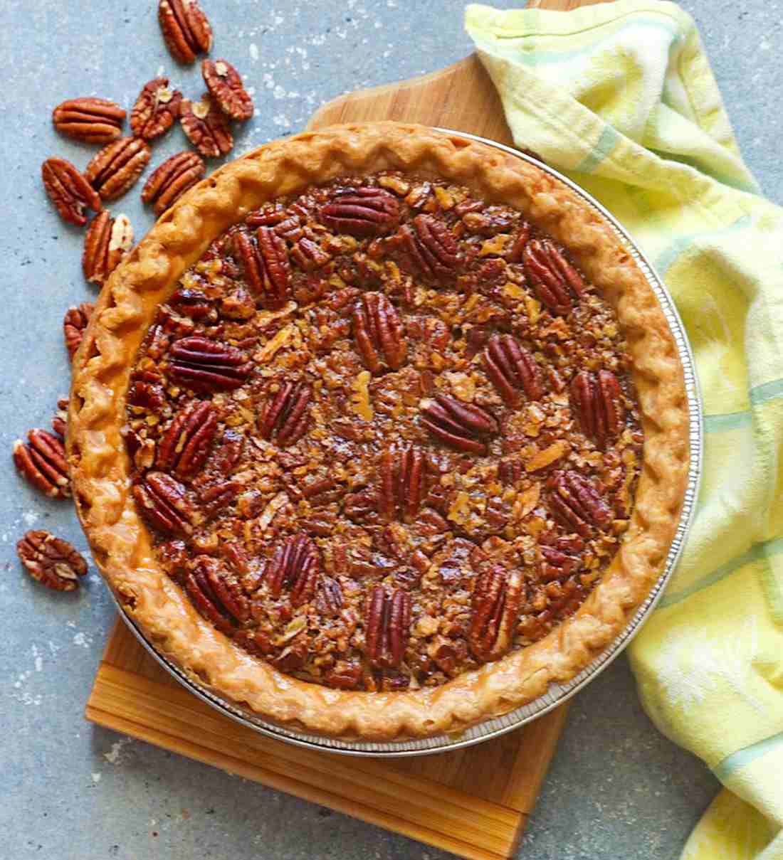 Slice of bourbon pecan pie with golden caramel filling and toasted pecans on flaky crust