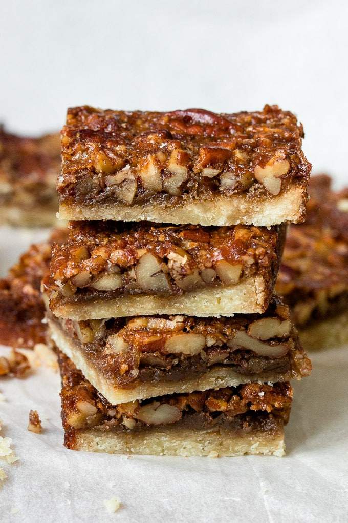 Golden pecan pie bar square featuring toasted pecans over caramel filling and shortbread crust