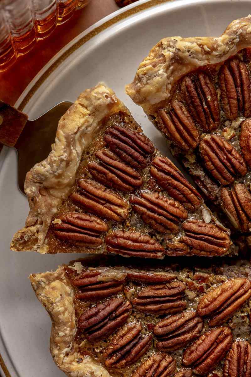 Golden bourbon pecan pie slice with rich caramel filling and toasted pecans on plate