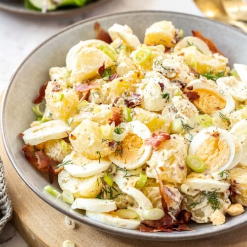 Herbed creamy potato salad featuring tender potatoes, tangy dressing, fresh chives, and crunchy celery