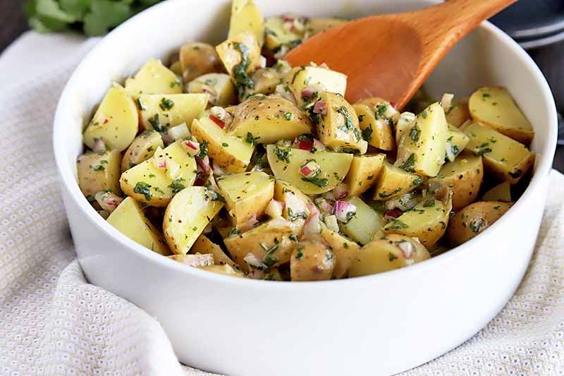 Summer picnic creamy potato salad with tender potatoes, herb dressing, crunchy celery, bright herbs