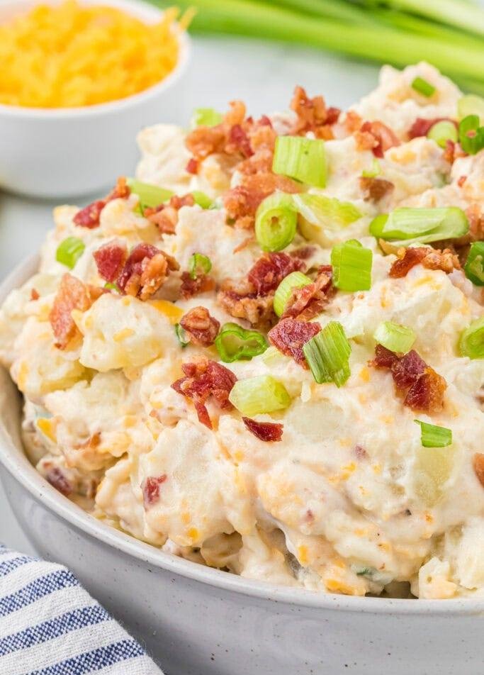 Loaded baked potato salad with tender potatoes, creamy dressing, crisp bacon, chives, and cheddar