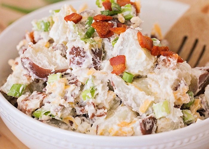 Crunchy loaded baked potato salad with potatoes, bacon, cheddar, green onions, and creamy dressing