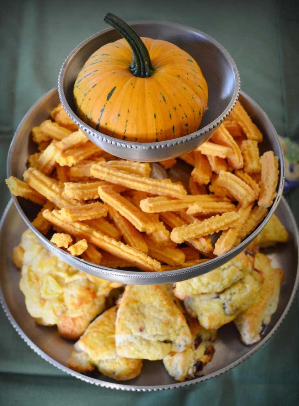 Golden cheese straws and pumpkin scones arranged on a white ceramic plate